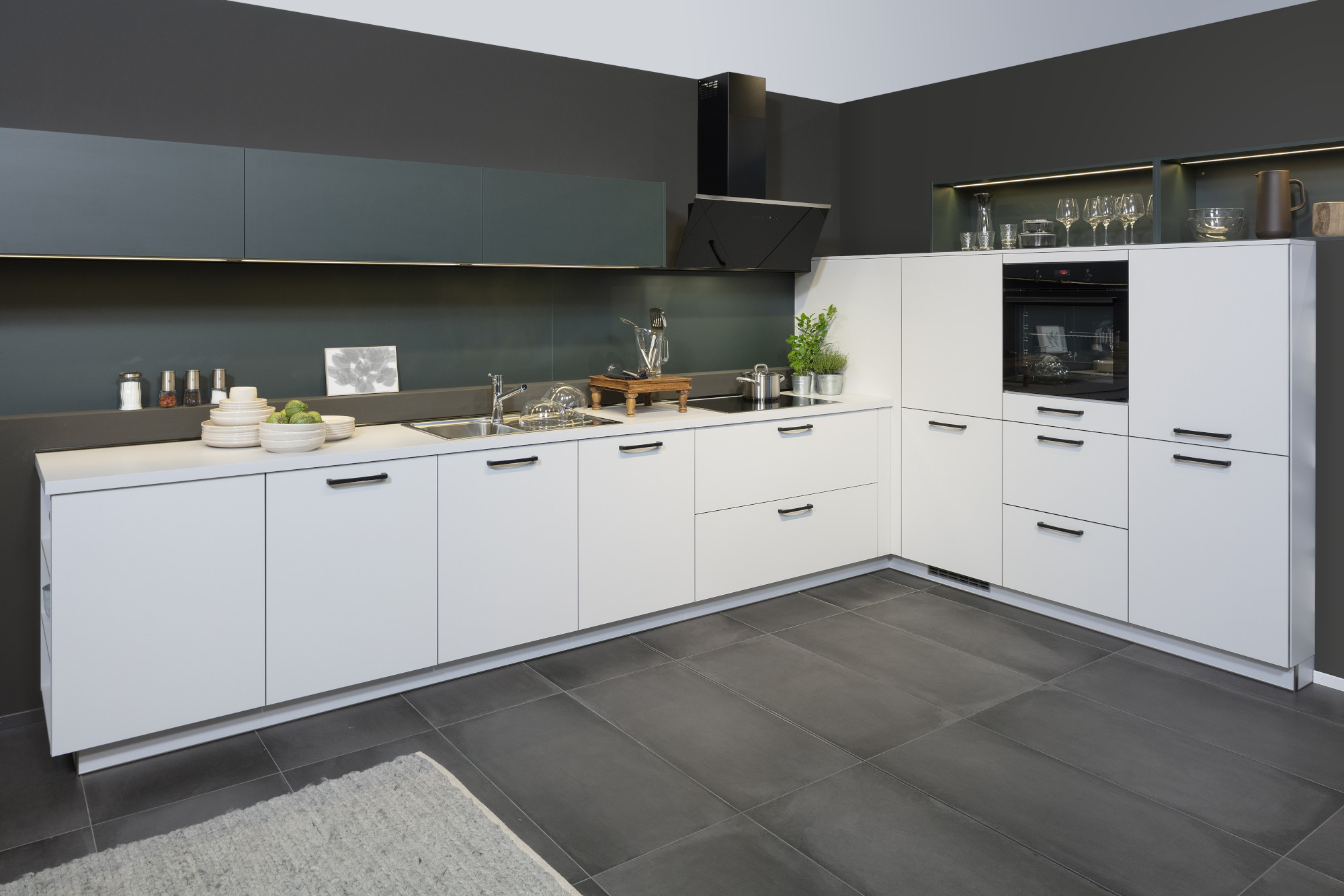 Moderne weiße Einbauküche mit dunklem Boden und Geräten