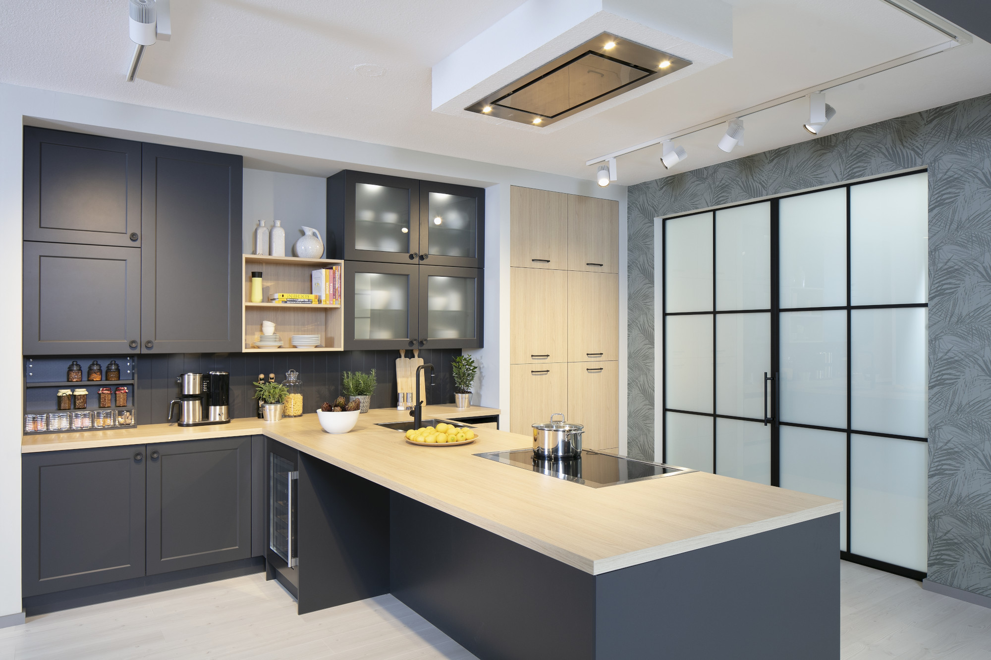 Moderne Küche mit Kochinsel, dunklen Schränken und Glas-Schiebetür.