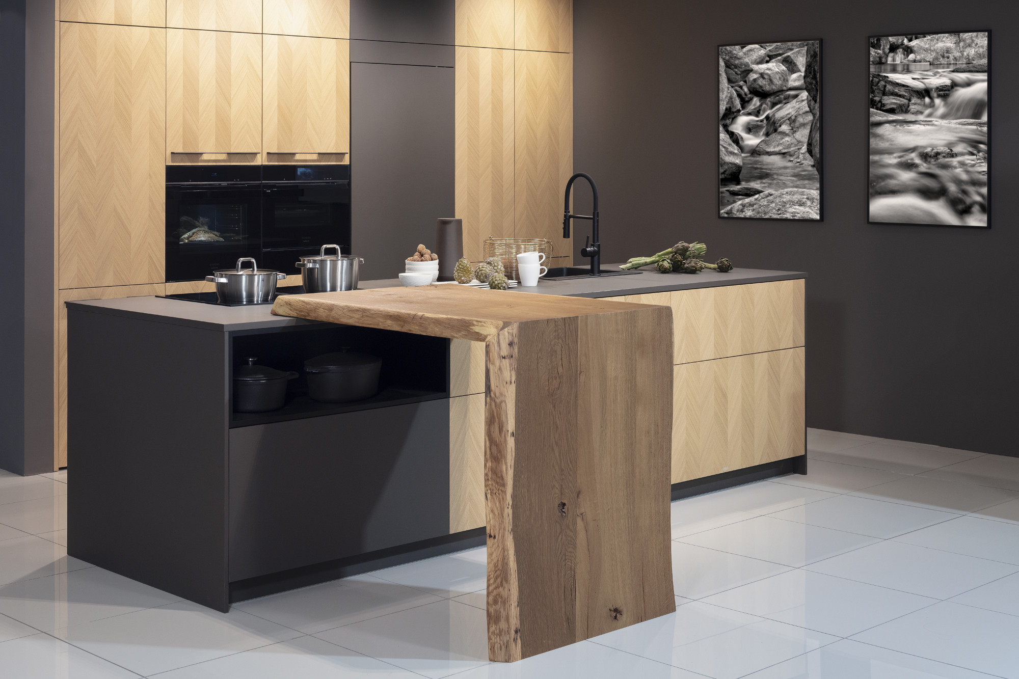 Moderne Küche mit Holzfronten, Kochinsel und zwei Schwarz-Weiß-Bildern an der Wand.