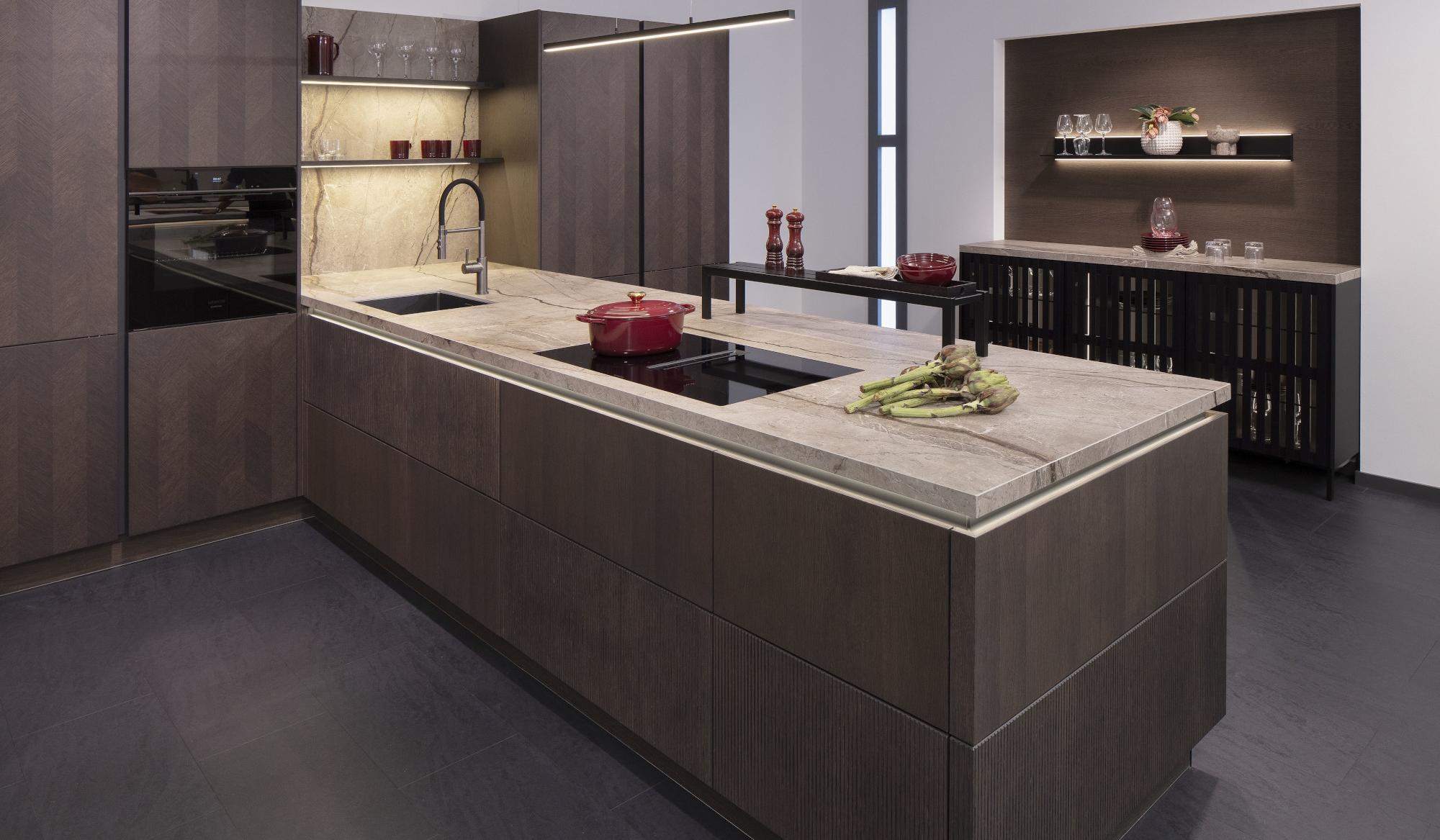 Moderne Küche mit dunklen Schränken, Kochinsel und beleuchteten Regalen